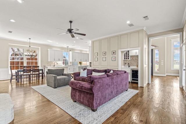 living room featuring ornamental molding, wine cooler, dark wood-style flooring, and visible vents