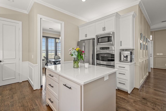 kitchen featuring white cabinets, dark wood-style flooring, stainless steel appliances, and crown molding