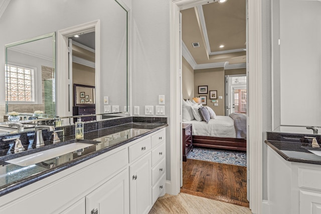 ensuite bathroom featuring recessed lighting, wood finished floors, vanity, and crown molding