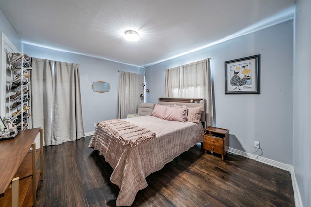 bedroom with dark wood-type flooring and baseboards