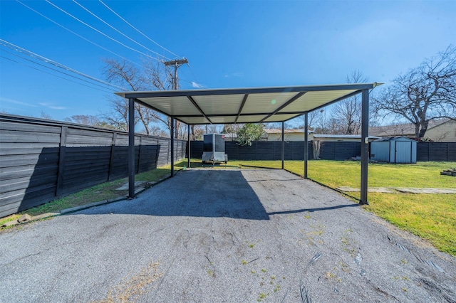 1216 Fuller Dr, Dallas, TX 75218 - view of parking featuring a carport, fence, aphalt driveway, and a shed