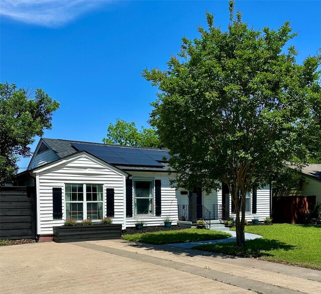 1216 Fuller Dr, Dallas, TX 75218 - view of front of house with a front lawn, fence, and solar panels