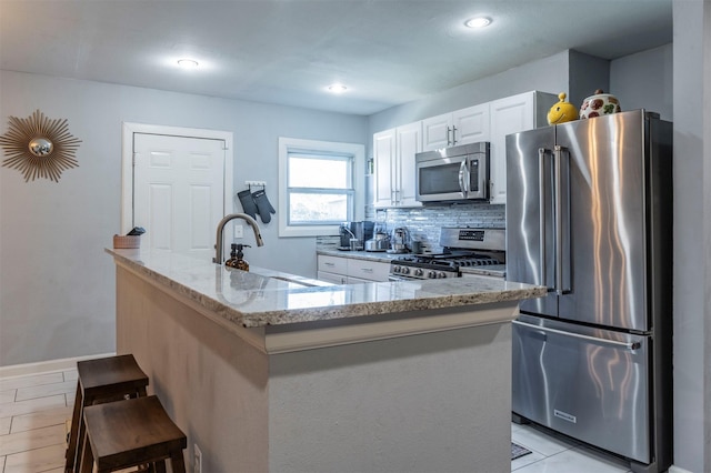 1216 Fuller Dr, Dallas, TX 75218 - kitchen featuring a sink, stainless steel appliances, light stone counters, white cabinetry, and backsplash