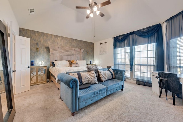 bedroom featuring lofted ceiling, light carpet, a ceiling fan, visible vents, and wallpapered walls