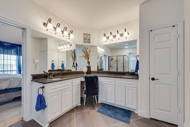 ensuite bathroom with a stall shower, tile patterned floors, ensuite bathroom, and vanity