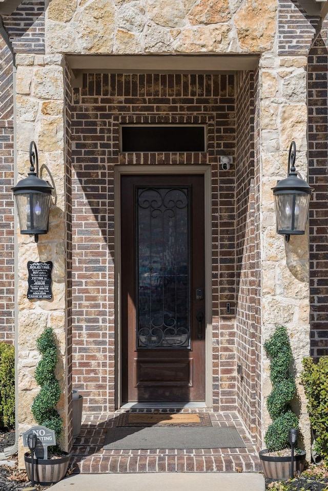 view of exterior entry with brick siding