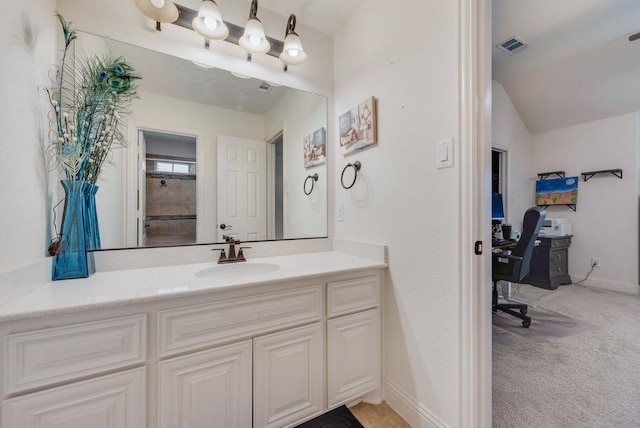 bathroom featuring visible vents, vaulted ceiling, vanity, and baseboards