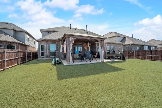 back of property featuring a yard, brick siding, a patio area, and a fenced backyard