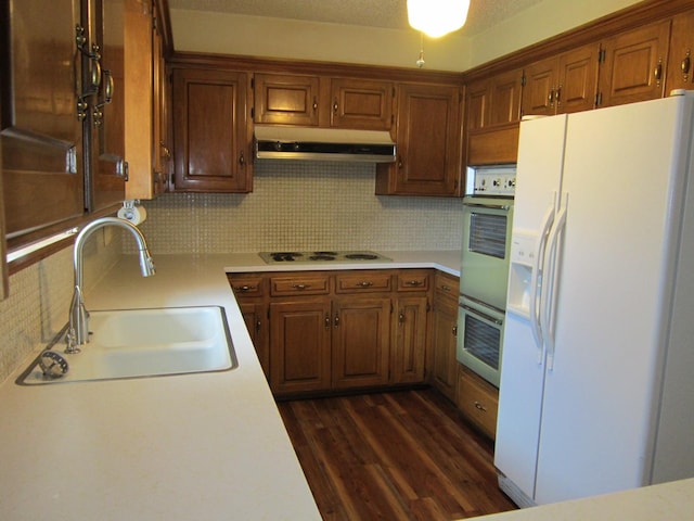 kitchen featuring white refrigerator with ice dispenser, light countertops, a sink, electric stovetop, and under cabinet range hood