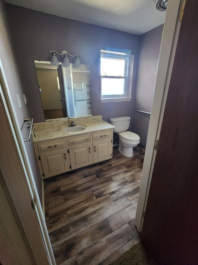 bathroom with vanity, toilet, and wood finished floors