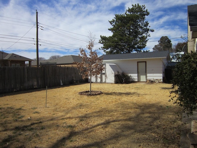 view of yard with a storage shed, fence, and an outdoor structure