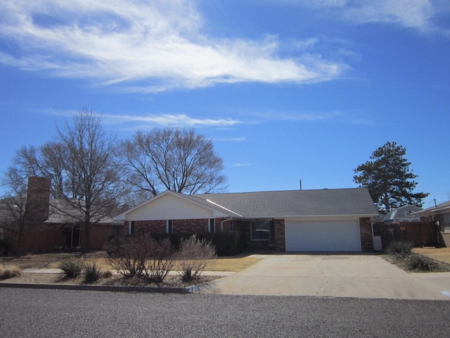 single story home with a garage, driveway, and brick siding