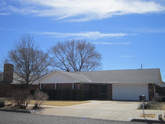 ranch-style home featuring a garage, concrete driveway, and brick siding