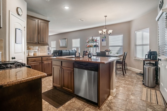 kitchen with a center island with sink, visible vents, stainless steel dishwasher, light stone countertops, and a chandelier