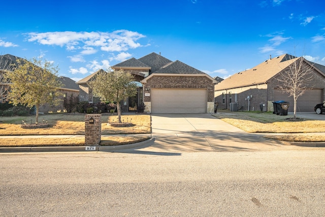 view of front facade with cooling unit, a garage, brick siding, concrete driveway, and roof with shingles