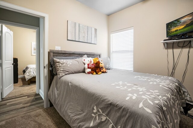 carpeted bedroom featuring wood finished floors