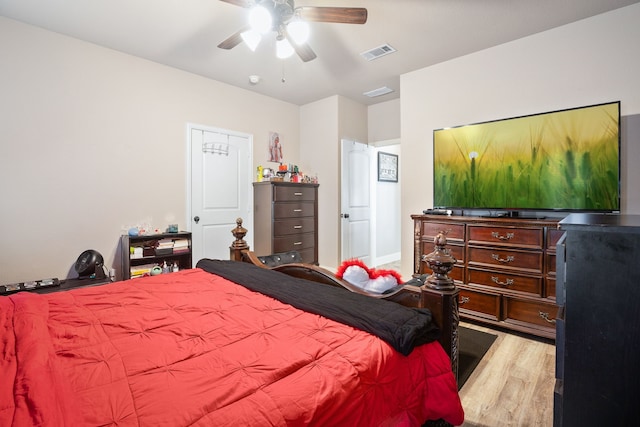 bedroom with ceiling fan, wood finished floors, and visible vents