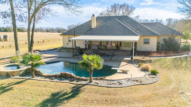 rear view of house with a chimney, central AC unit, a patio area, an in ground hot tub, and an outdoor pool