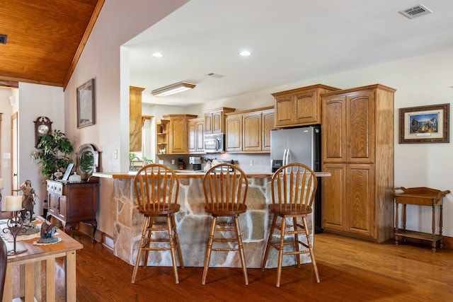 kitchen featuring stainless steel appliances, visible vents, a kitchen bar, and open shelves