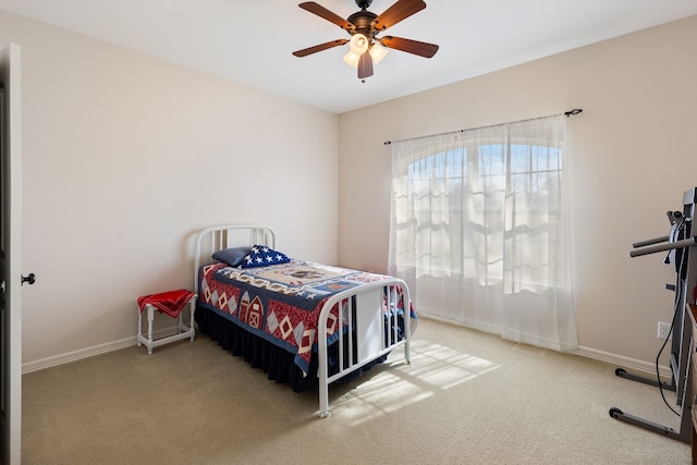 carpeted bedroom with ceiling fan and baseboards