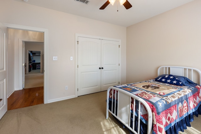 bedroom with carpet floors, visible vents, baseboards, a ceiling fan, and a closet