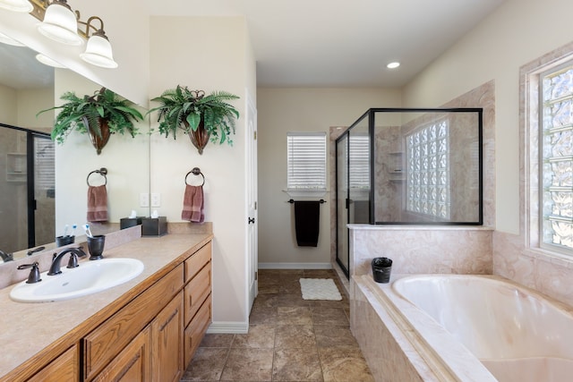 bathroom with a garden tub, a shower stall, baseboards, and vanity