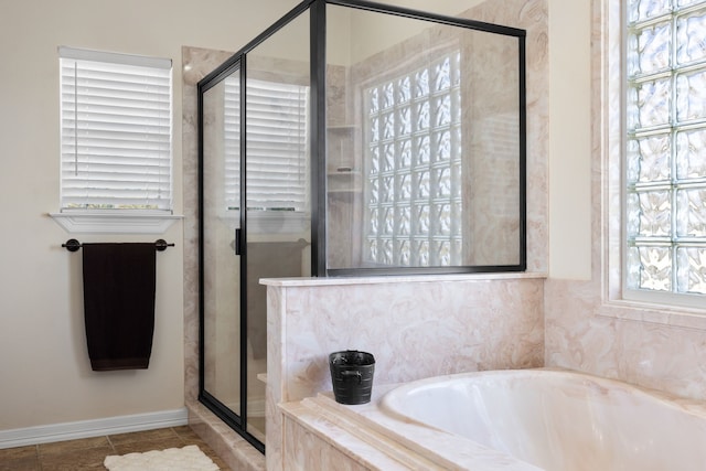 bathroom with a stall shower, baseboards, a bath, and tile patterned floors