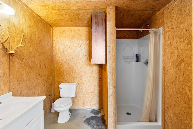 bathroom with toilet, a shower stall, concrete flooring, and vanity