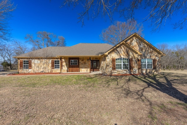 view of front of house featuring stone siding and a front lawn