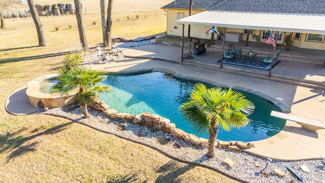 outdoor pool with a patio area and a diving board