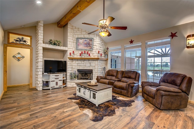 living room with a ceiling fan, a fireplace, wood finished floors, baseboards, and lofted ceiling with beams