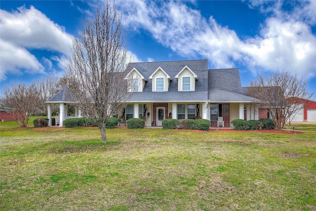 cape cod home featuring brick siding, a front lawn, and covered porch