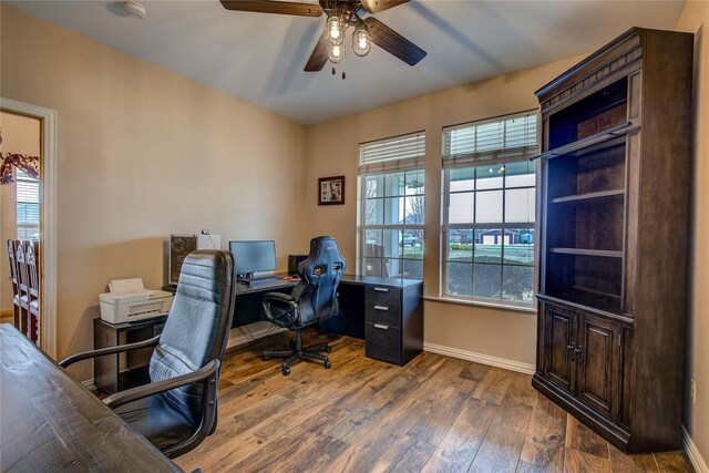 office area with baseboards, ceiling fan, and wood-type flooring