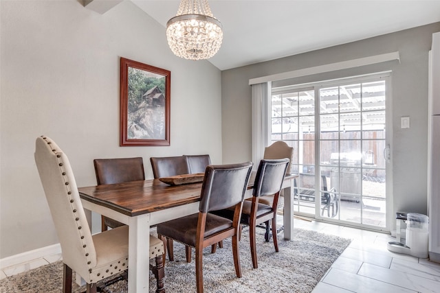 dining area featuring lofted ceiling, baseboards, and a notable chandelier