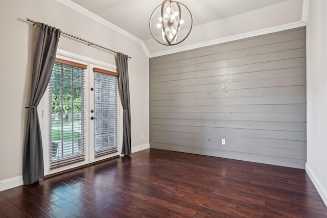 unfurnished room with an inviting chandelier, french doors, crown molding, and wood finished floors