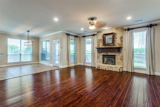 unfurnished living room featuring a fireplace, wood finished floors, visible vents, baseboards, and crown molding