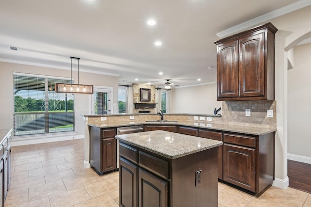 kitchen featuring ornamental molding, a center island, a sink, dark brown cabinets, and backsplash