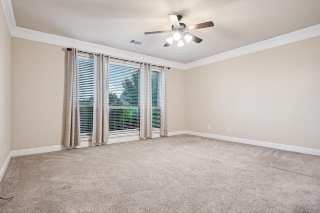 carpeted empty room featuring baseboards, visible vents, a ceiling fan, and ornamental molding