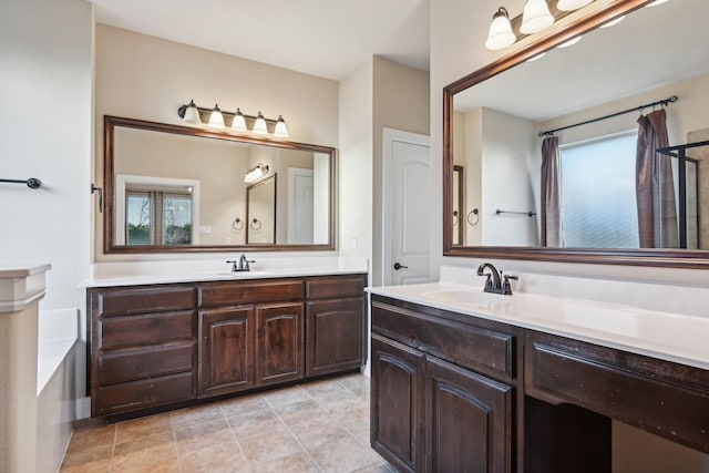 bathroom with a bath, tile patterned flooring, vanity, and a healthy amount of sunlight