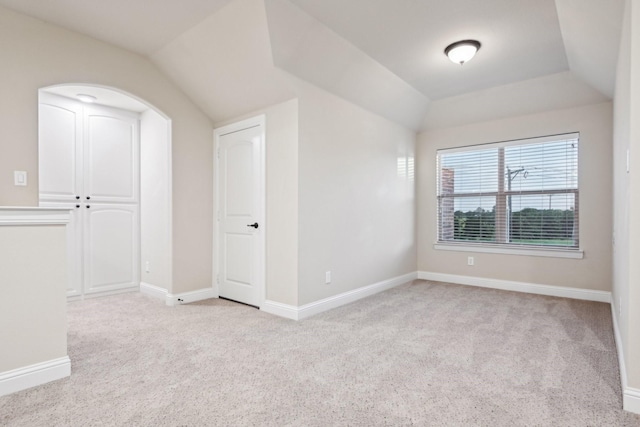 bonus room with light carpet, baseboards, and lofted ceiling