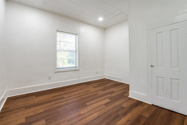 empty room with baseboards and wood finished floors