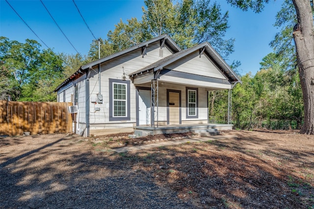 view of front of property featuring covered porch, cooling unit, and fence