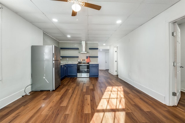 kitchen with wall chimney range hood, stainless steel appliances, light countertops, blue cabinetry, and open shelves