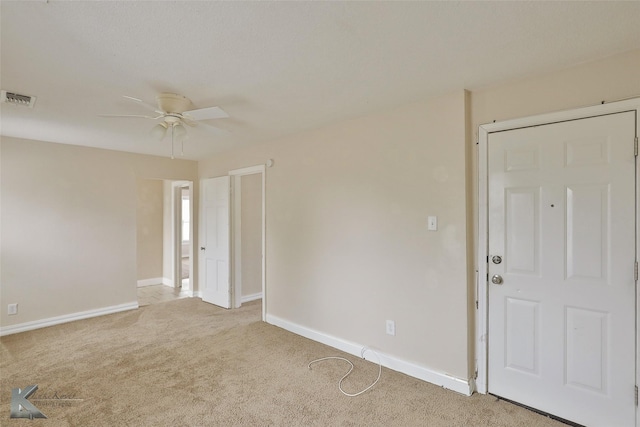 spare room featuring a ceiling fan, baseboards, visible vents, and carpet flooring