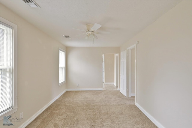 unfurnished room featuring a ceiling fan, carpet flooring, visible vents, and baseboards