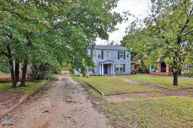 view of front of house featuring dirt driveway and a front yard