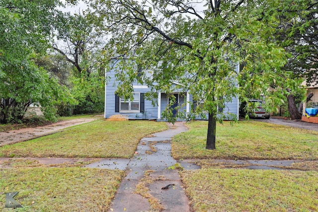 obstructed view of property with a front yard