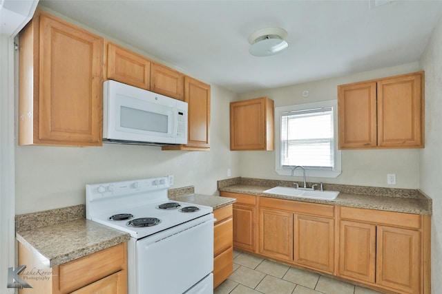 kitchen featuring light tile patterned floors, white appliances, and a sink