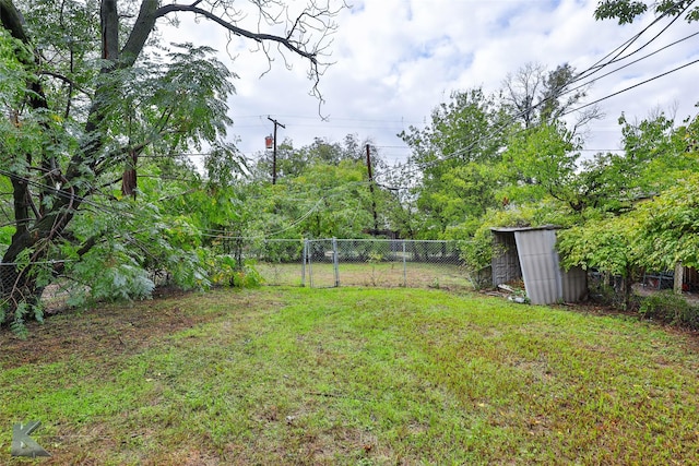 view of yard with fence and an outbuilding