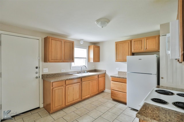 kitchen with freestanding refrigerator, electric stove, a sink, and light tile patterned floors